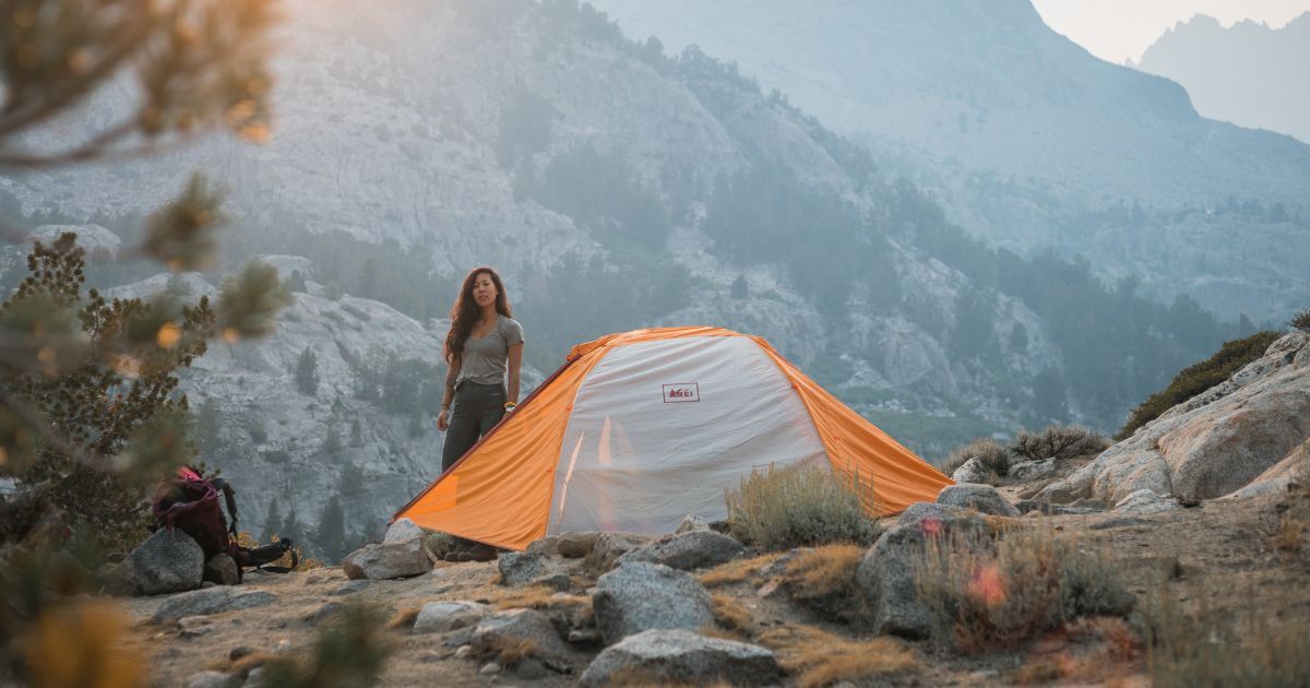 woman standing next to her tent