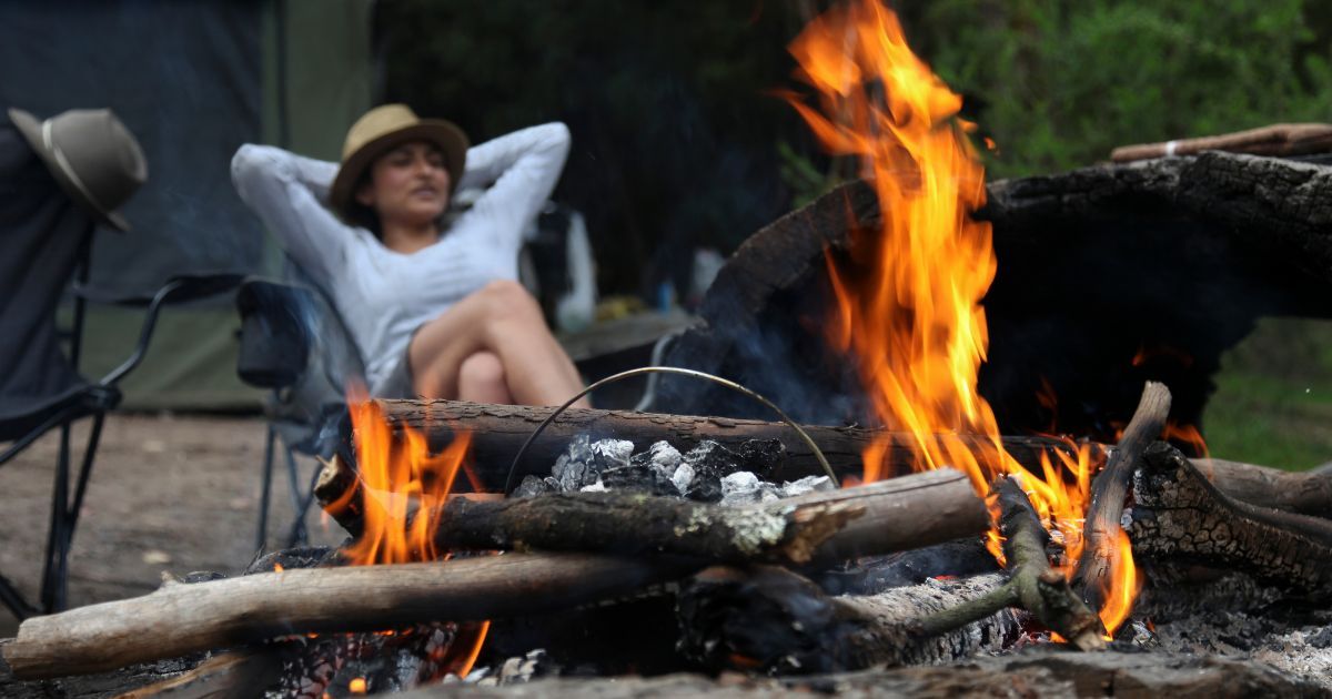 woman relaxing by a campfire