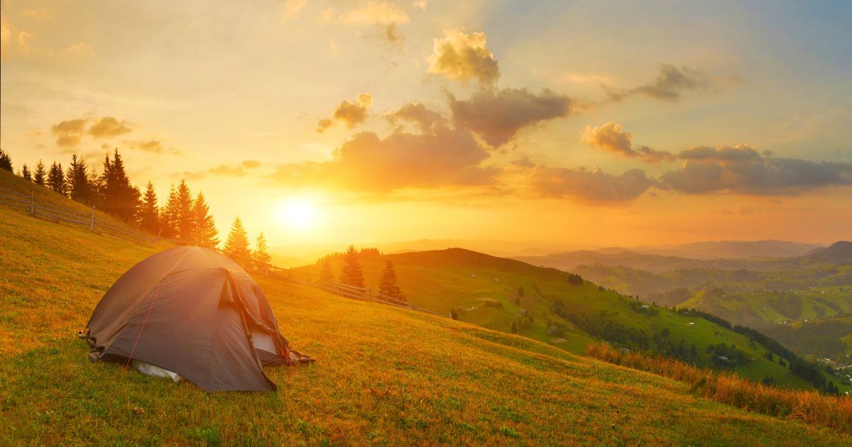 tent setup during sunset on a hillside
