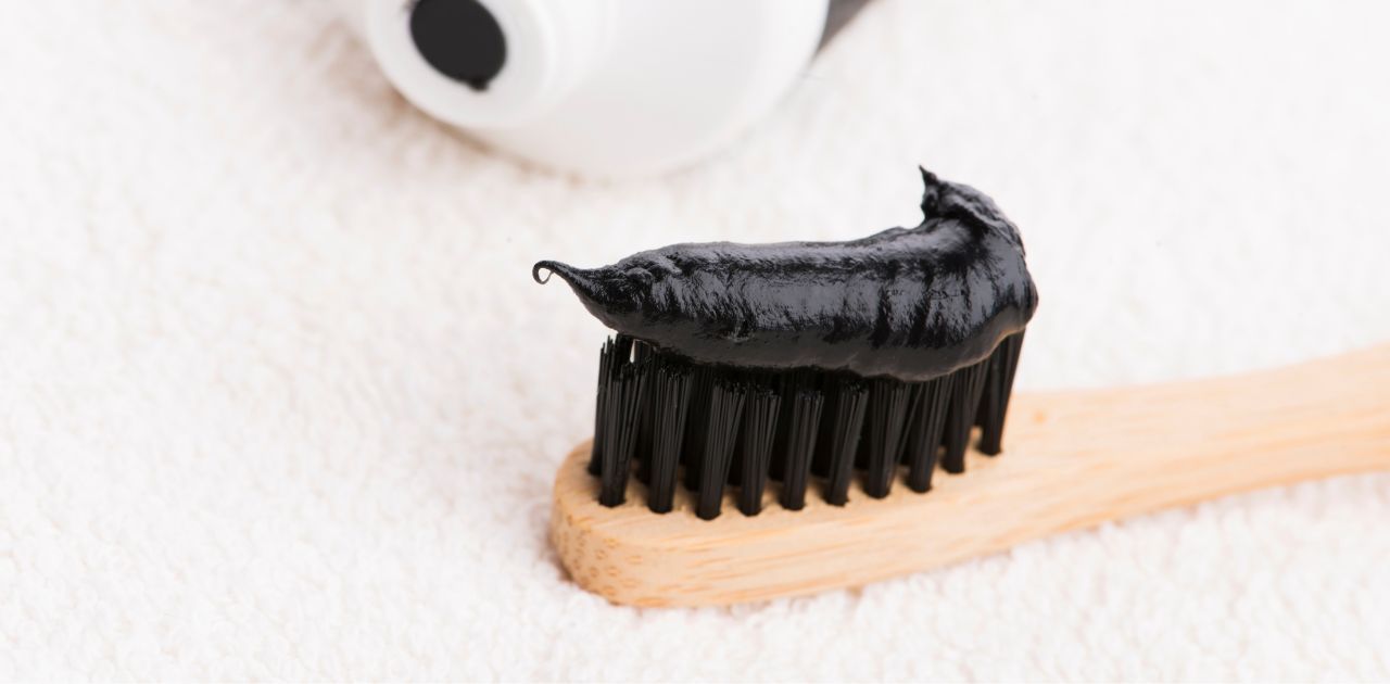 close up of toothbrush with charcoal toothpaste