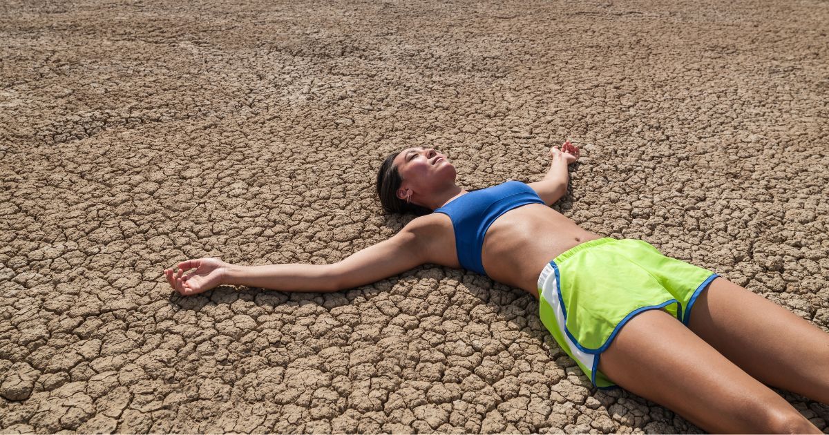woman laying on dried up cracked ground