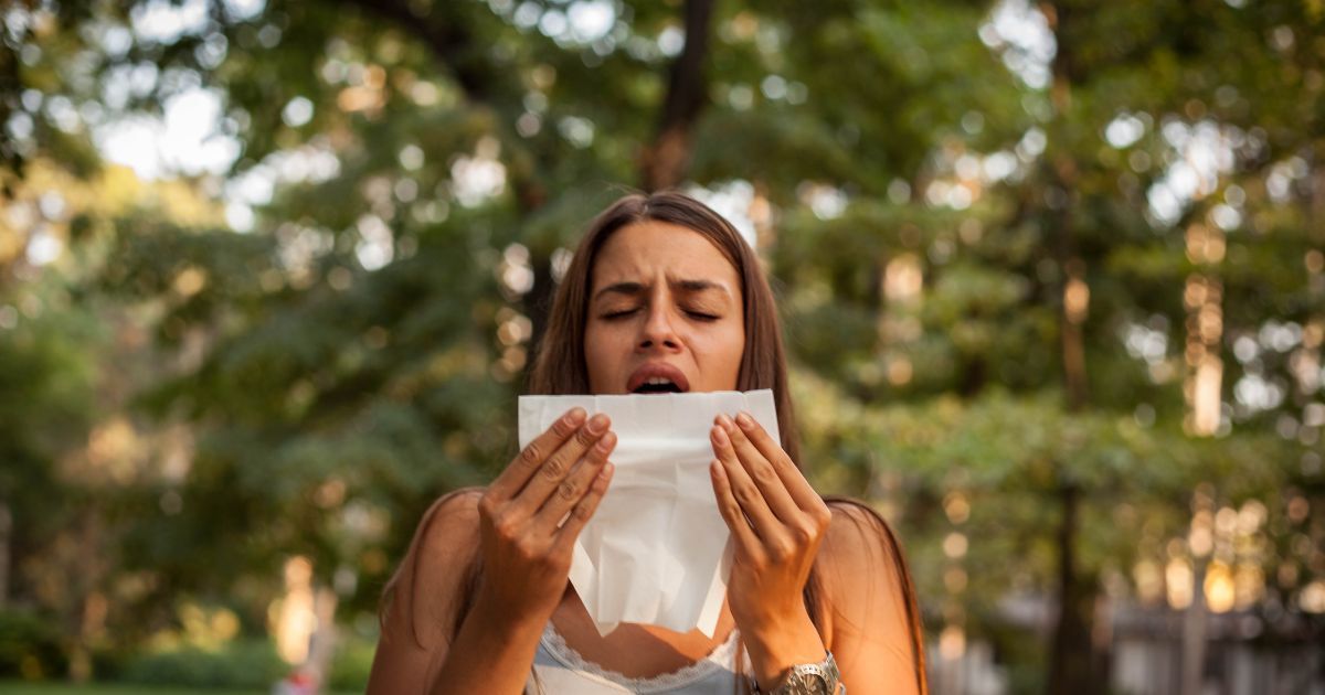 woman about to sneeze in tissue