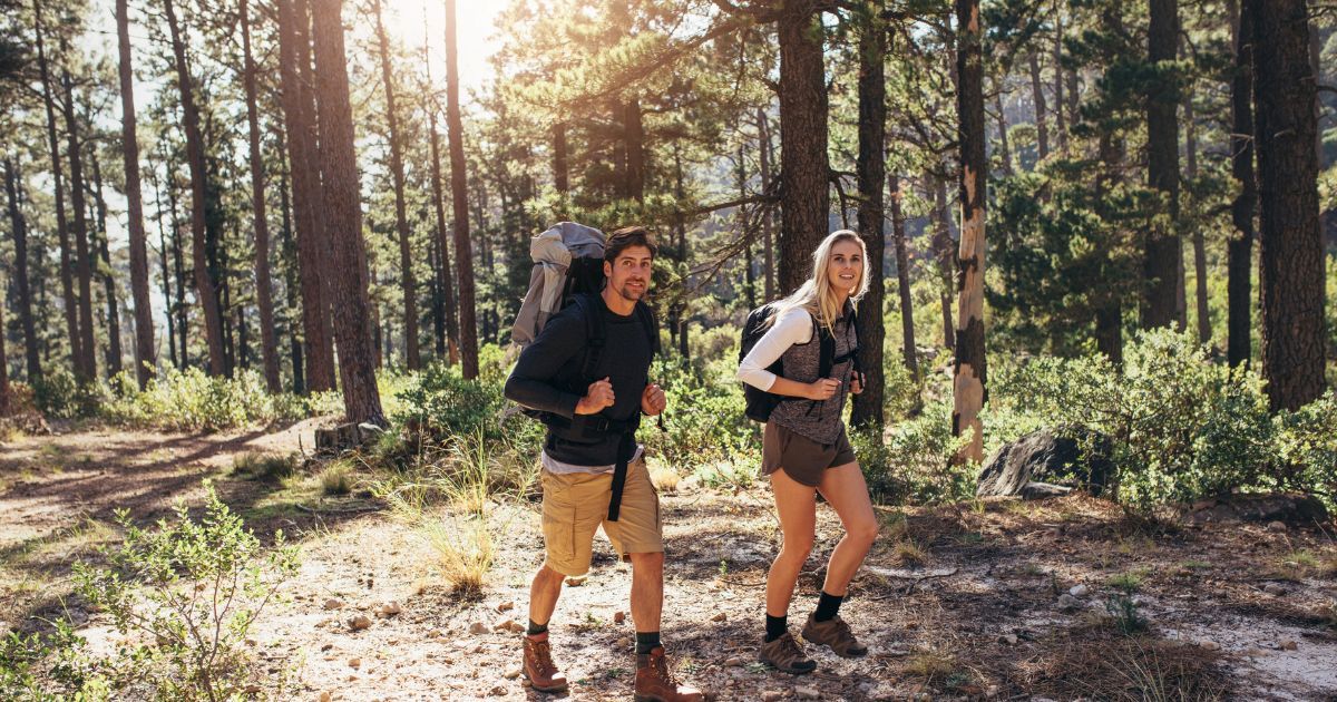 man and woman hiking in forest