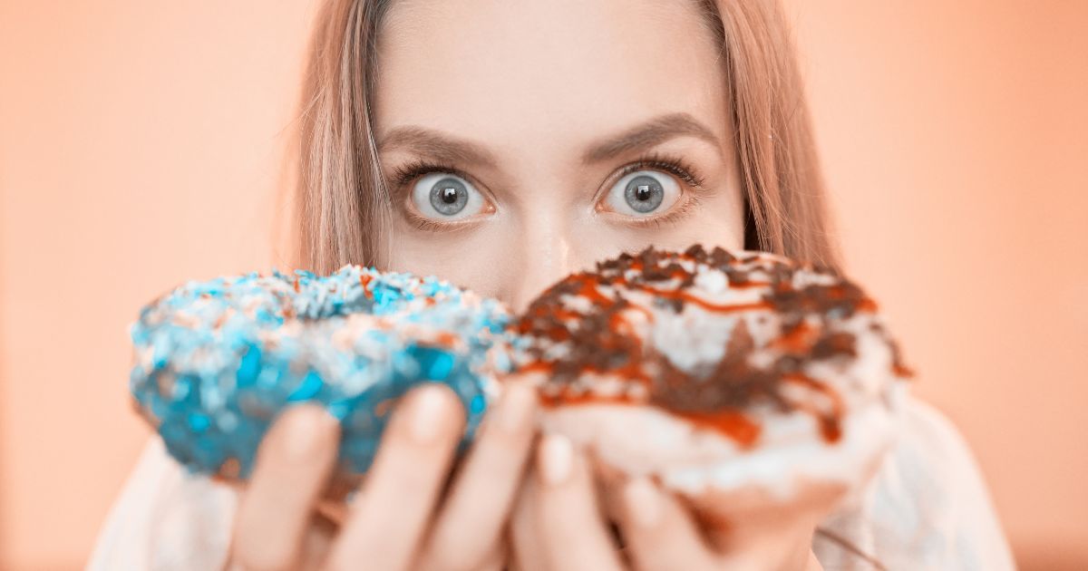 portrait of woman holding up donuts
