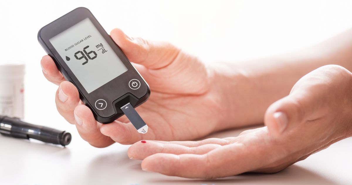 person using blood glucose monitor