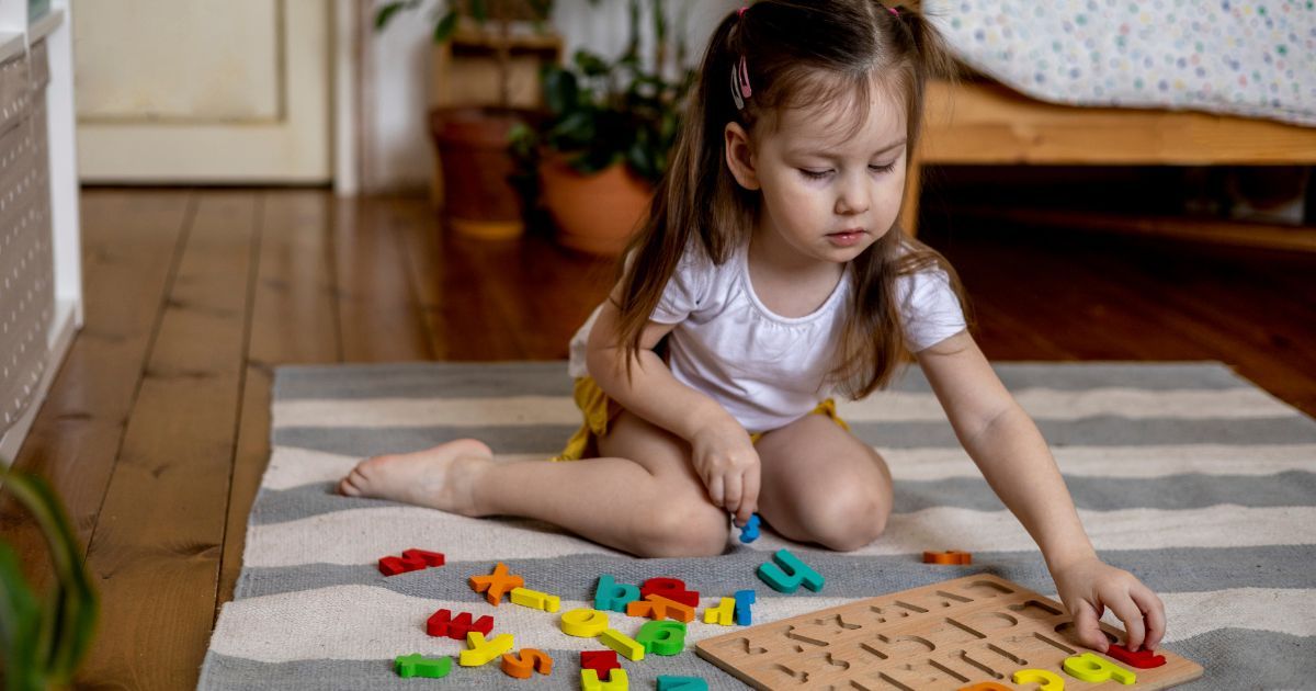 girl playing with alphabet letters