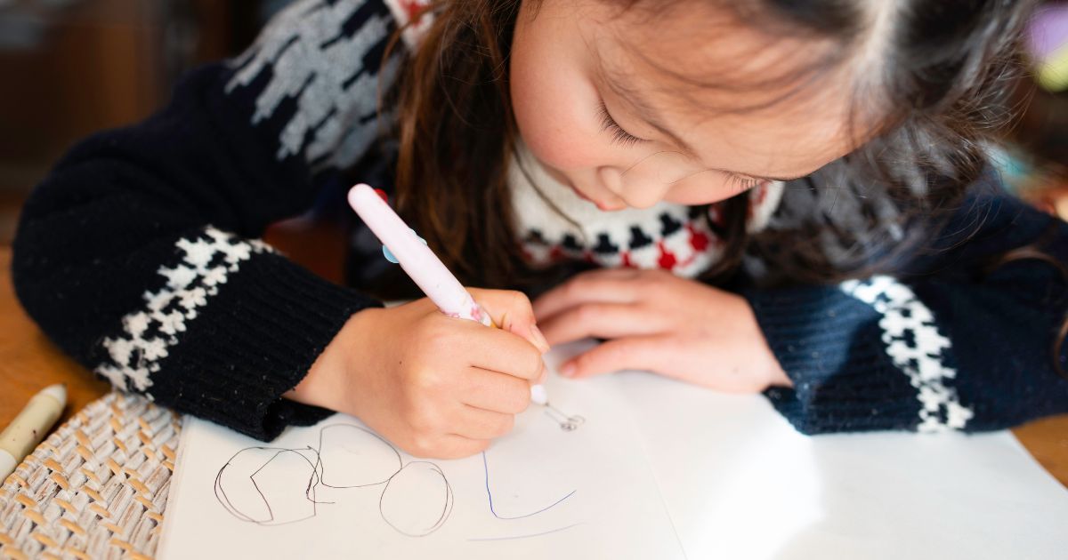 little girl writing on paper