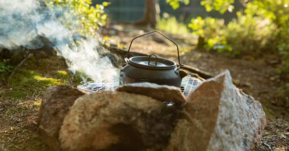 kettle on grate over campfire