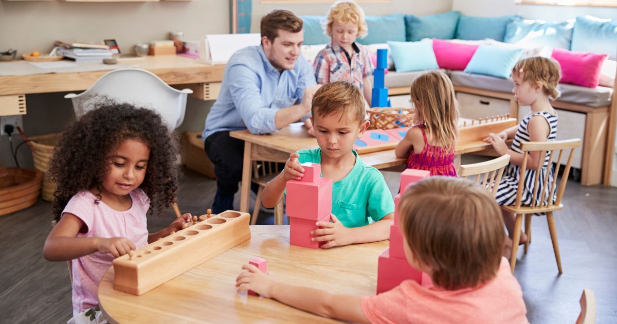 teacher and pupils working at a table in a Montessori classroom