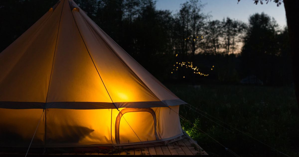 canvas tent at night, soft glow inside