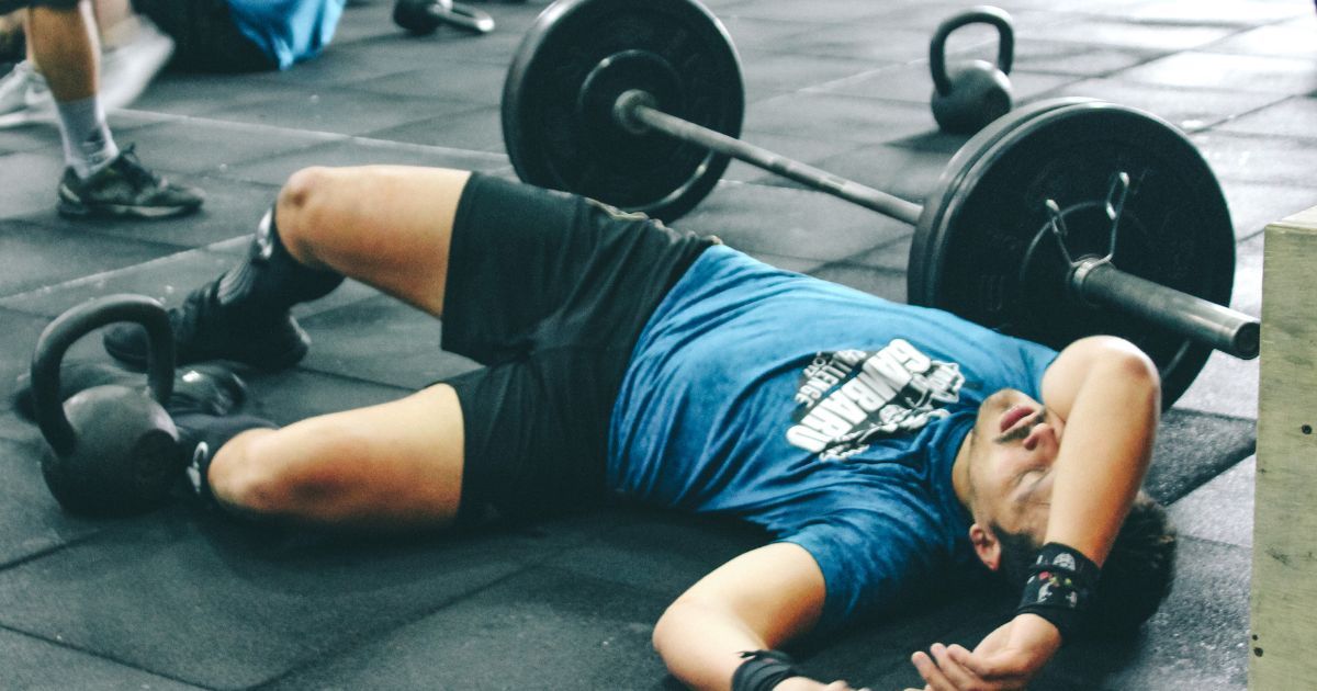 man lying down in exhaustion after workout