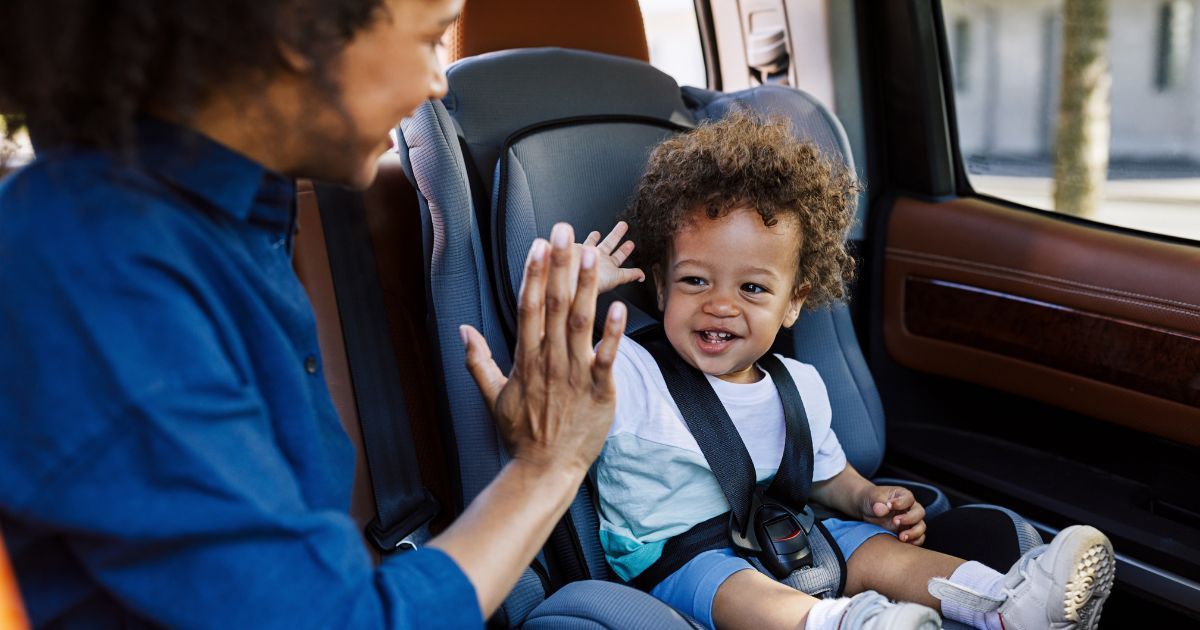 mom high five child in car seat