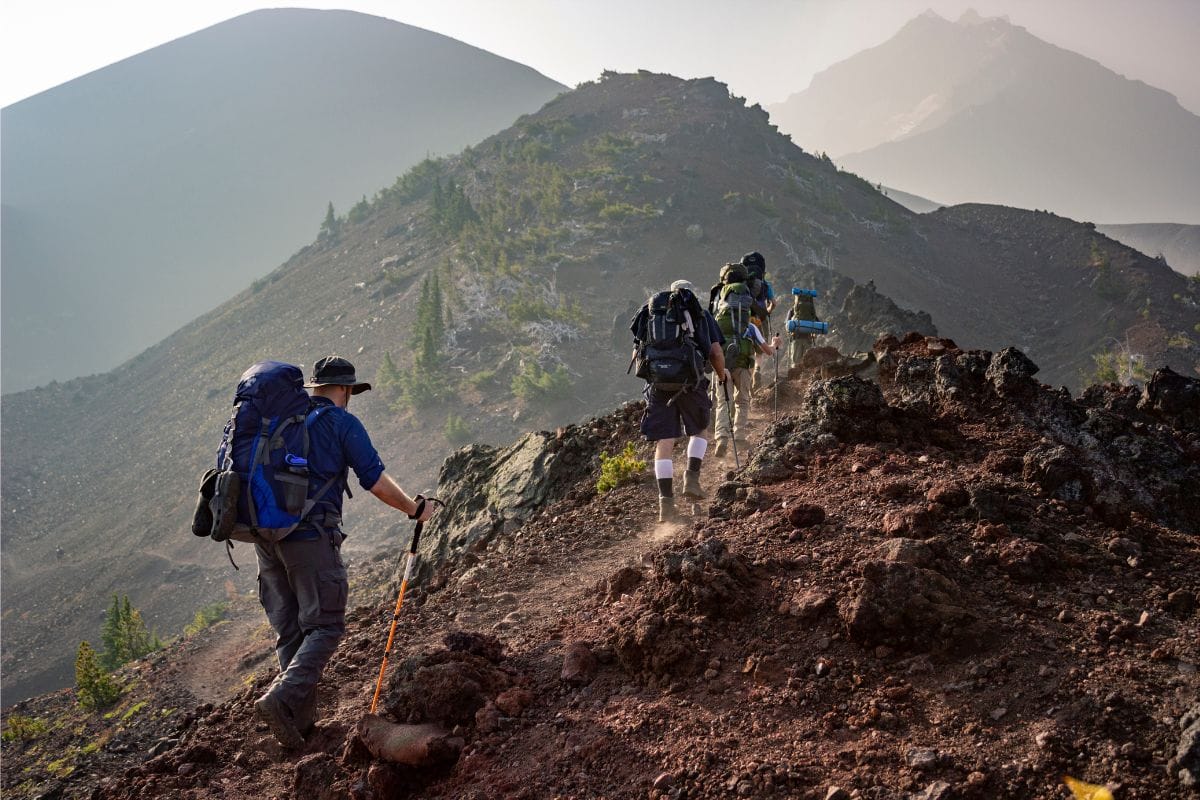 people hiking with backpacks on a ridgeline