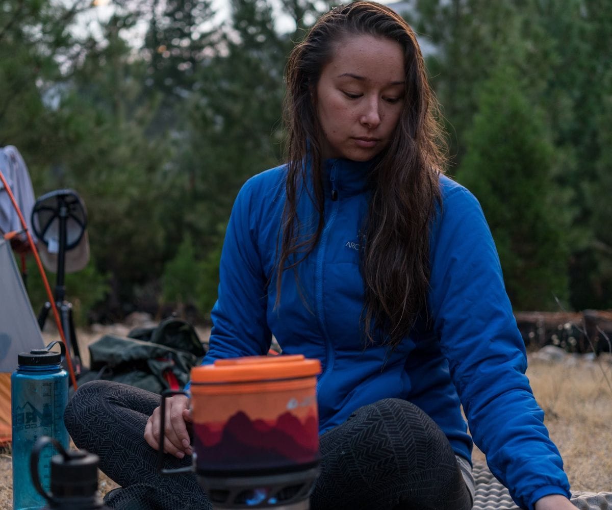 girl cooking food in the backcountry