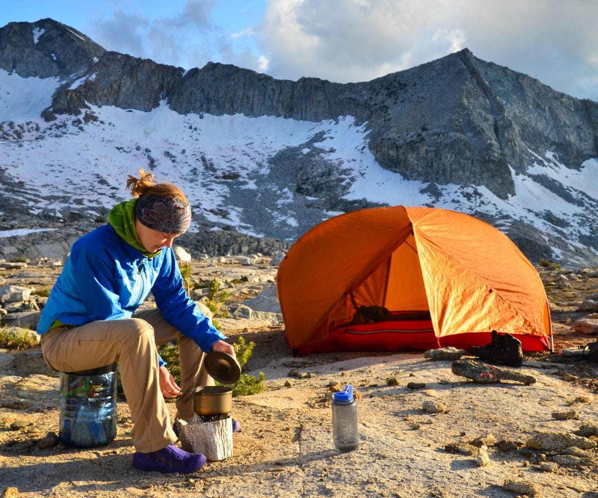 woman cooking food in the backcountry