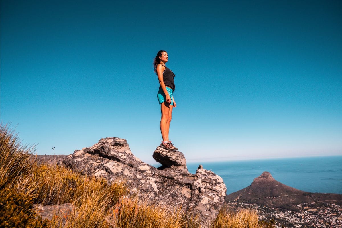 woman outdoors standing on rock on a sunny day
